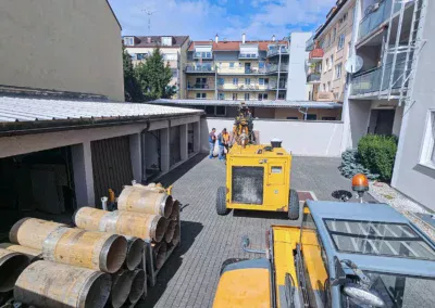 Schluckbrunnen mit 13 m Endteufe: Kleinbohrgerät HD100 im Hinterhof, erreichbar nur über eine enge Durchfahrt